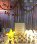 Three Piece 3D Moon Cloud Star LED Night Light Set for Kids and Adults at a gender reveal party with cupcakes