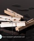 Large Wooden Clothes Pins 2.9 Inch 50 Pack Built Tough Galvanized Coil Springs shown on black surface with water droplets.