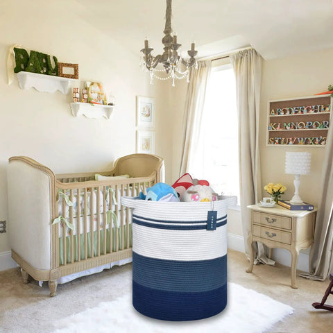 Gradient blue oversized cotton rope laundry hamper in nursery with crib, toys, and chandelier, suitable for storage of clothes, towels.