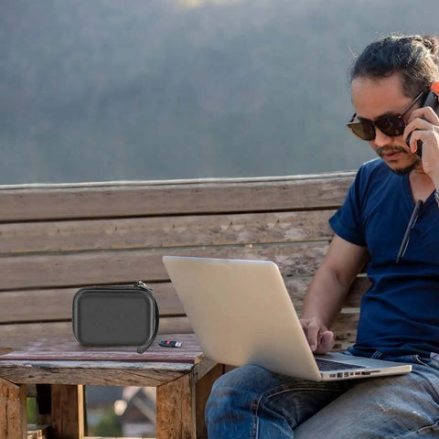 Slick Heavy Duty Foam Carry Case For Forty Four Usb Sticks And Nine Sd Cards on a wooden table next to a laptop outdoors.