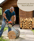 Man cutting firewood with chainsaw next to log storage rack bracket displaying stacked firewood in backyard.