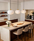 Vaziden Milk Glass Pendant Lights Kitchen Island Gold Chandelier 11.81" above a modern kitchen island with beige seating.