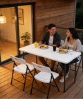 Couple dining outdoors on Heavy Duty 4 Foot Folding Table With Fold In Half Design Adjustable Height Grab And Go Portable Utility Table With Steel Legs For Indoor Outdoor Picnics Camping Dining And Parties White.