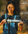 Person adjusting pro grade bike repair stand with 360 degree clamp and spinner knob for precise closure, focus on clamp and pads.