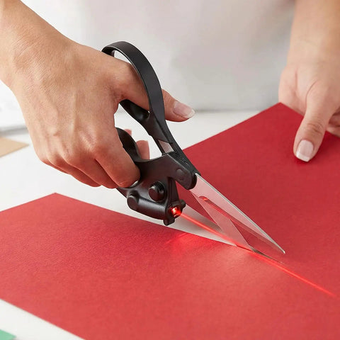 Hand using Laser Guided Scissors for Fabric and Paper Cutting, Infrared Laser Line for Crisp Straight Cuts on red paper