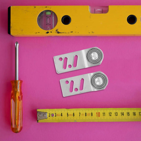 4 Pack Badass Stainless Steel Sliding Door Pulley Wheels with 23mm Axle Bore Hella Smooth Ball Bearing Rollers on pink background.