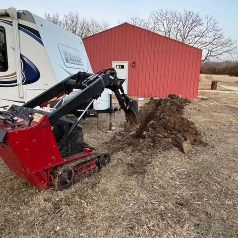 Heavy duty mini skid steer using 12 Inch Front Hoe Hydraulic Tilt Bucket for digging soil near a red building.