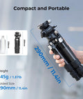 Hand holding Pro Grade Carbon Fiber Tabletop Tripod Kit With 17 Inch Compact Desktop Design, folded size 290mm, next to bottle.