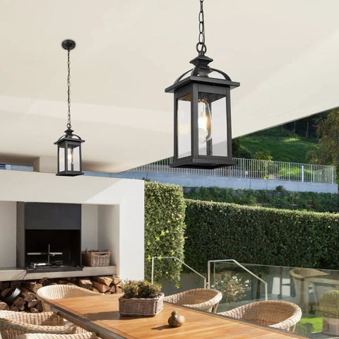 Outdoor Pendant Light Lanterns Two Pack White Aluminum With Seeded Glass hanging over patio table and chairs