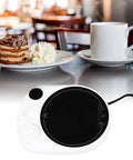This Solid Electric Mug Warmer Boasts Four Heat Presets To Keep Your Daily Brew Piping Hot All Day Long Featuring Smart Auto Shut Off Protection And Fast Heating With A Sleek White Top For Desk Setup, shown with cake and coffee.