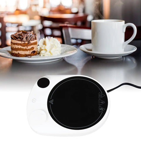 This Solid Electric Mug Warmer Boasts Four Heat Presets To Keep Your Daily Brew Piping Hot All Day Long Featuring Smart Auto Shut Off Protection And Fast Heating With A Sleek White Top For Desk Setup, shown with cake and coffee.