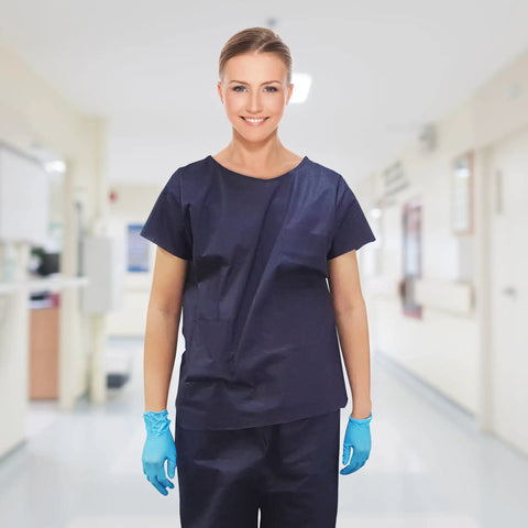 Model wearing Pack Of Ten Dark Blue Disposable Scrub Shirts Unisex Adult Large Lightweight Spunbond Polypropylene.