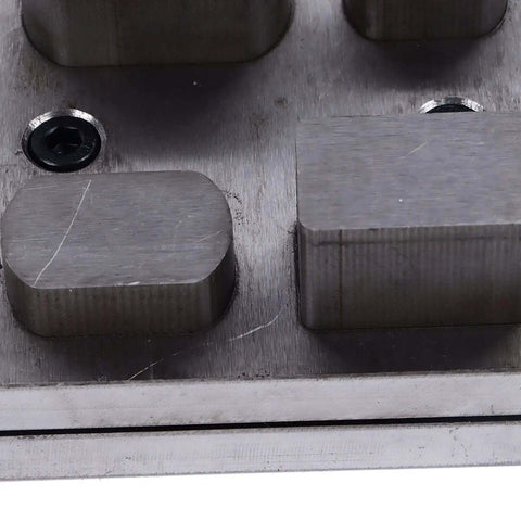 Close-up of Durable Alloy Disc Cutter Set For Jewelry Making and Metal Crafting, showing irregular shape punches on steel base.
