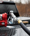 Vented Diesel Transfer Tank Cap With Threaded Neck And Two Inch Base visible on a truck toolbox next to a fuel pump.