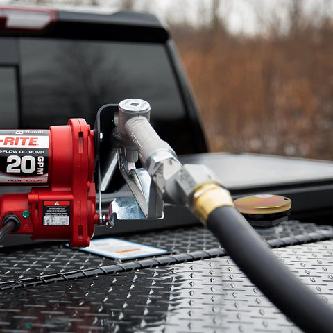Vented Diesel Transfer Tank Cap With Threaded Neck And Two Inch Base visible on a truck toolbox next to a fuel pump.