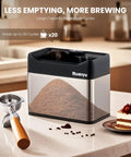 Automatic Portafilter Washer With Three Liter Tank Efficient Three Way Valve Rapid Drainage Fits 51 And 58 Millimeter Espresso Machines stainless steel portafilter cleaner with ground coffee on countertop.