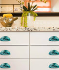 Premium Teal Marble Cabinet Cup Pulls Boasting A Killer Stone Finish on white kitchen drawers with granite countertop.