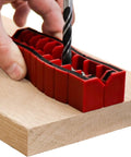 Drill Block Plus Handheld Drilling Guide for DIYers aligned on wood with drill bit, showing nine imperial drill bit sizes.
