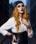 Badass Punk Leather Bracelet Set With Studded Spike Cuffs And Skull Details Kicking Up That Dope 80s Rock Vibe worn by a model with blonde hair.