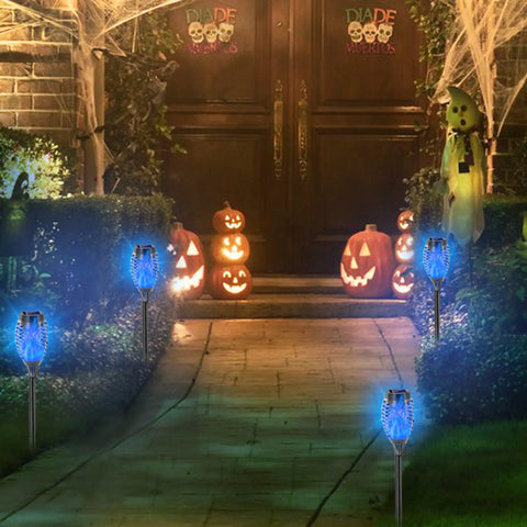 Pathway lit by Blue Solar Torch Lights Set, 8 Pack Outdoor LED Tiki Torches With Realistic Flickering Flame, 12 LEDs, Waterproof Landscape Decor