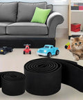 Adjustable Under Couch Blocker With Hella Secure Elastic Strap Blocks Toys And Small Items From Sliding Under Furniture Great Pet Safe Gap Cover To Skip Floor Searches Today, roll of elastic strap in front of a couch, toys and a cat visible.
