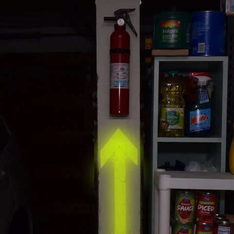 Bright yellow arrow pointing to a fire extinguisher beside kitchen pantry items.