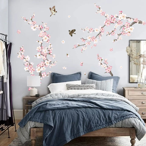 Cherry Blossom Wall Decals Set With Pink And White Flowers And Tree Branches Peel And Stick Wall Art For Living Room And Bedroom Durable Waterproof Self Adhesive PVC Matte Totally Easy To Apply No Residue Left Behind displayed above bed in bedroom.