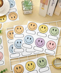 Smiley Name Tags Pack 120 Pcs Boho Pastel Smile Face Nameplates for Classroom and Office Labeling on a table