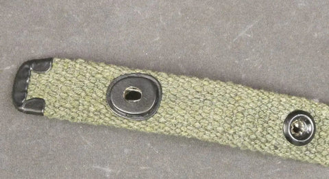 Close-up of WWII M1 Carbine web sling with lift-the-dot closure and OD green canvas material for reenactments.