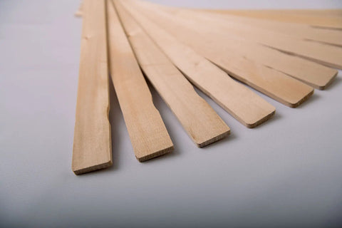 American-Made Basswood Paint Stir Sticks 21 Inch Bulk 250 Count laid out in a fan pattern for 5-Gallon Buckets
