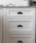 Matte Black Cabinet Cup Pulls Two And A Half Inch Center To Center Pack Of 10 installed on white kitchen drawers