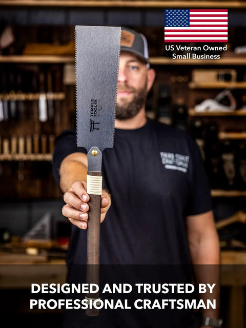 Pro Grade Japanese Pull Saw With Dual Rip And Crosscut Blades held by a craftsman in a workshop, showcasing its sharp blade design.