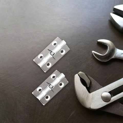 Two Pack Stainless Steel Hidden Door Hinges With Automatic Self Closing Spring For Cabinet And Interior Doors 45x35mm on table with tools