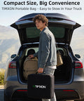Person holding a TIMXON portable bag and backpack at an open car trunk in a scenic landscape