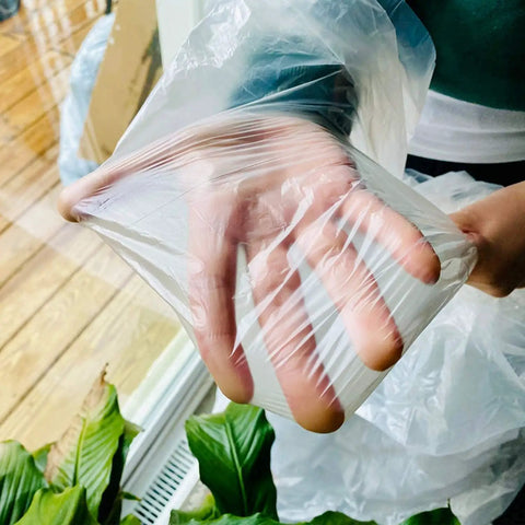 Hand showing flexibility of Clear Plastic Drop Cloths For Painting, 5 Pack 9x12 Feet Tarp Heavy Duty Waterproof Dustproof Tear Resistant.
