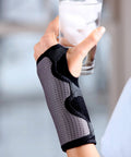Reversible Wrist Brace for Sore, Weak, and Injured Wrists, Breathable Comfort, adjustable splint, holding a glass of water