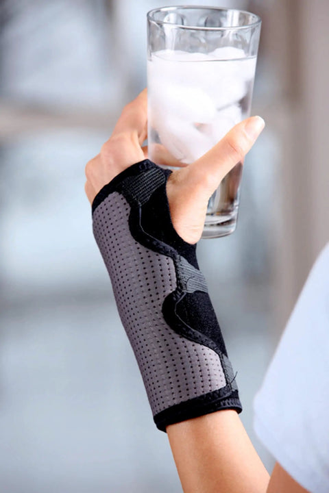 Reversible Wrist Brace for Sore, Weak, and Injured Wrists, Breathable Comfort, adjustable splint, holding a glass of water
