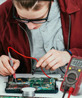 Person using DIY Ready Pro Grade TRMS 6000 Counts Digital Multimeter With Auto Ranging NCV Capability on electronic circuit board