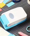 Dope Tiny Paper Punch Hole Puncher For Scrapbooking And Photo Albums, Oval Shape; acrylic and metal craft tool on a desk.