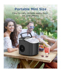 Portable Countertop Ice Maker With No Sweat Self Cleaning Generates Nine Gentle On Teeth Cubes In Just Six Minutes placed on outdoor table with drinks.