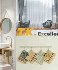 Collage of modern bathroom, reading area with chairs, and hanging newspapers on white walls in bright room.