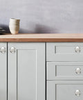 Top Shelf 10 Pack 1-1/4 Inch Heavy Duty Solid Round Cabinet Knobs Polished Nickel on grey kitchen cabinetry.