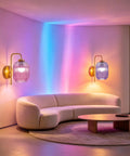 Rechargeable Battery Wall Sconces With Clear Glass Shades, Customizable Rgb Lighting Paired With Seamless Dimmable Levels And Adjustable Color Temperatures, vibrant ambient lighting in modern living room with curved sofa.