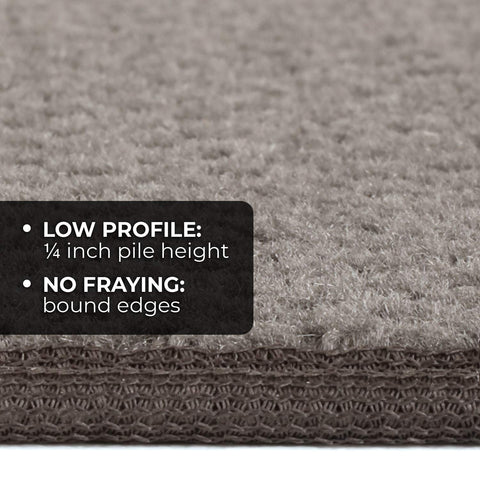 Close-up of gray non-slip carpet stair tread, showing low profile 1/4 inch pile height and bound edges for durability.