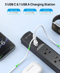 Flat Plug Power Strip With Three USB C Ports And One USB A, 1440 Joules Surge Protector in use with devices, black color.