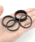 Hand holding 6 Pack 1 1/8 Inch Aluminum Bike Headset Spacers Set Anodized Black For MTB BMX Road Bikes With 2mm 3mm 5mm 10mm Shims