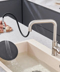 Universal Kitchen Faucet Replacement Head Pull Down Spray Nozzle With Fifteen Heavy Duty Adapters in use, washing a black plate in brushed nickel sink.