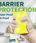 Hand wearing vinyl disposable exam glove holding a yellow sponge in a kitchen, showcasing waterproof and oil-proof protection.