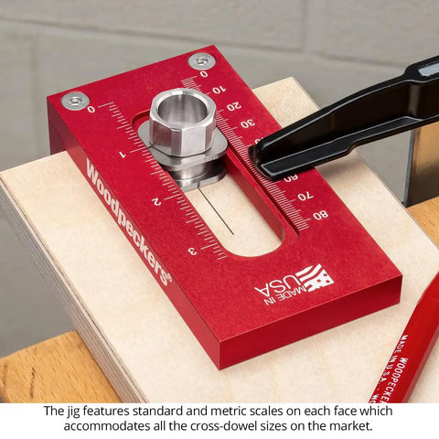 Universal Cross Dowel Jig Deluxe Kit Featuring Seven Heavy Duty Drill Guide Bushings For Bolts And Premium Wood Dowels close-up with scales on red metal base.