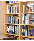 Books on wooden shelves in a home office, illustrating use of Cam Lock Pins Set For Do It Yourself Furniture And Cabinet Builds.